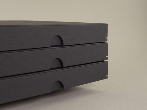 Detailansicht von drei handgefertigten schwarzen Design Boxen. Maße 23cm x 16,5cm x 2,5cm. Die Drahtheftung an jeder Ecke verleiht den Boxen einen hochwertigen Look.