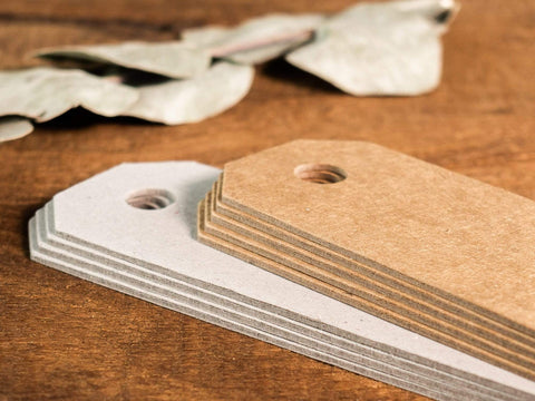 Detailansicht 8 hochwertige handgefertigte Geschenkanhänger zum selbst gestalten aus Kraftpapier mit Lochung. 4 Anhänger in Kraftkarton Natur, 4 Anhänger aus Graukarton. Format 4cm x 12cm.
