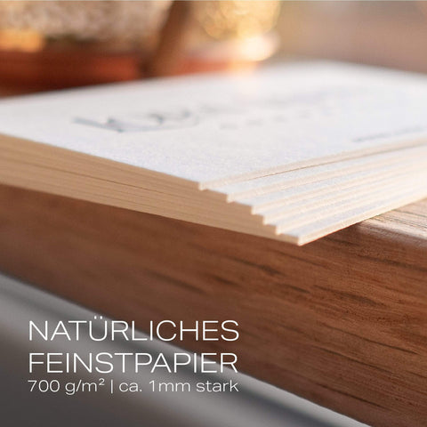 Detailaufnahme von 6 übereinander liegenden Letterpress Visitenkarten. Text "NATÜRLICHES FEINSTPAPIER 700 g/m² | ca. 1mm stark"