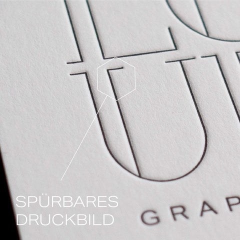 Detail of embossed letterpress design on a business card, showcasing tactile printing for a unique impression.