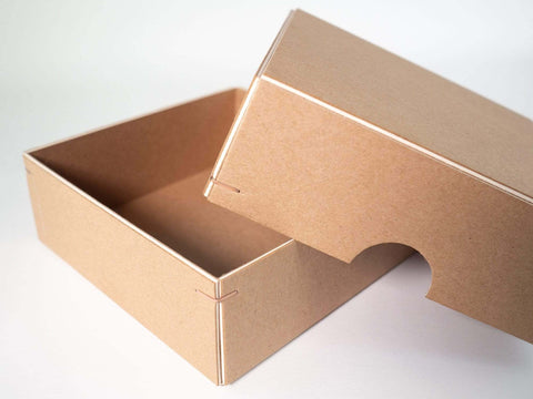 Handgefertigte Box aus Kraftkarton mit weißem Kern. Maße 12cm x 12cm x 4cm. Die Drahtheftung an jeder Ecke verleihen der Box einen hochwertigen Look.