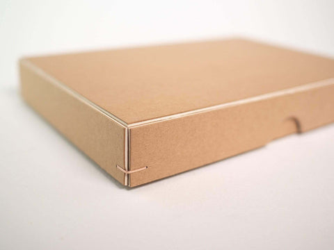Detailansicht einer Ecke einer handgefertigten Design Box aus Kraftkarton mit weißem Kern. Format 19cm x 13cm x 2,5cm. Die Drahtheftung an jeder Ecke verleiht der Box einen edlen Look.