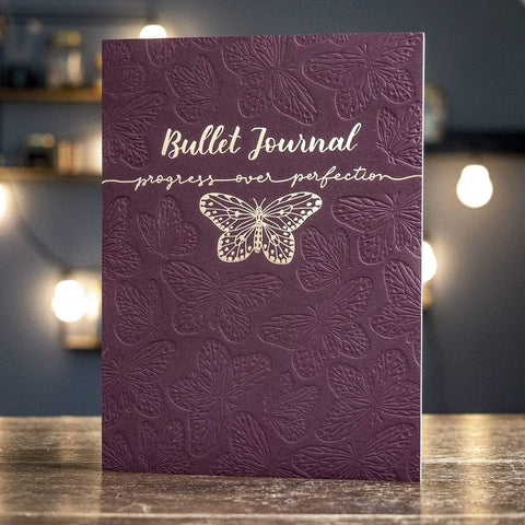 Letterpress Bullet Journal in Farbe Claret mit roségoldener Folienprägung. Schmetterlingsmuster als Blindprägung.